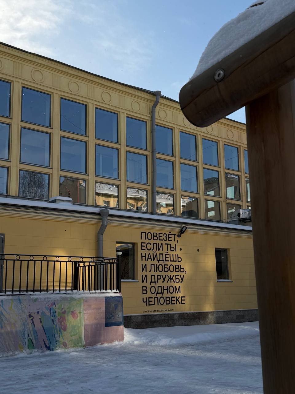 Архитектура здания Московского рынка снаружи с фирменной светящейся вышивкой-надписью.