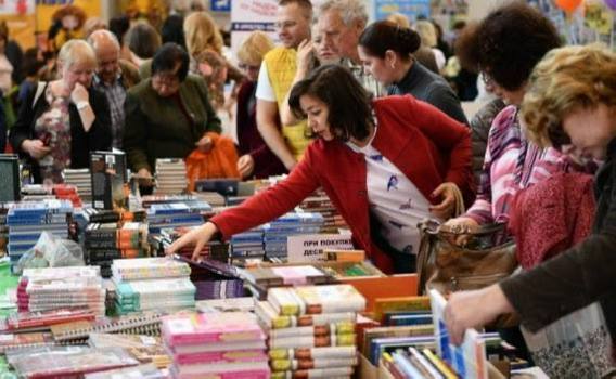 Книжный фестиваль в Екатеринбурге Девушка берет книгу в руки